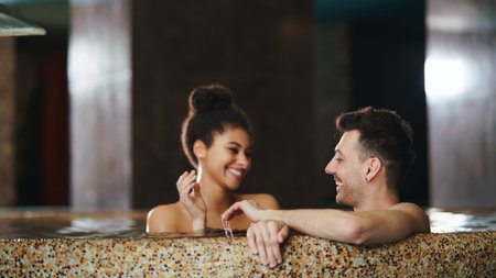 Portrait of happy young couple in love in swimming pool, having fun.の写真素材