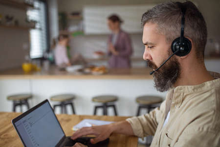 Businessman having video call indoors at home, everyday life and home office with child concept.の写真素材