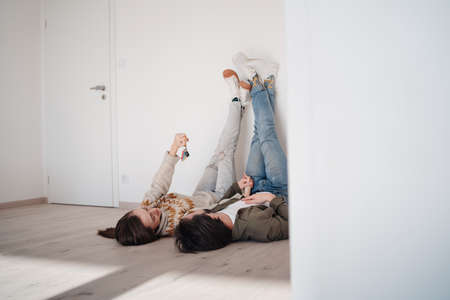 Young couple with keyslying on floor and moving in new flat, new home and relocation concept.の写真素材
