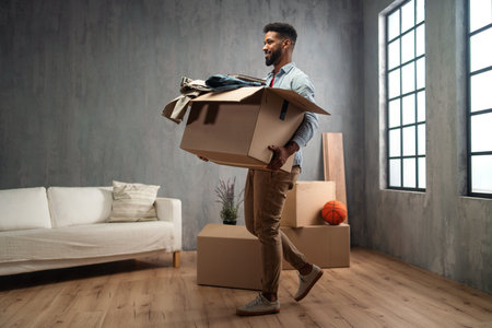 Happy young man holding packing boxes moving home, new living concept.