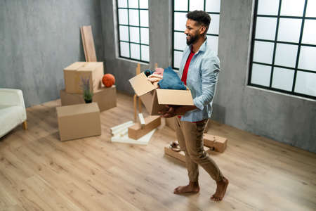 High angle view of happy young man holding packing boxes moving home, new living concept.の写真素材