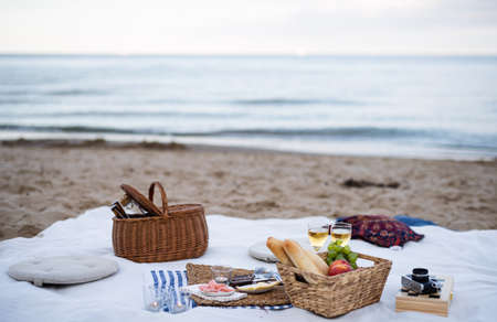 Beach picnic with schripms, beer, fruit and candlesの写真素材