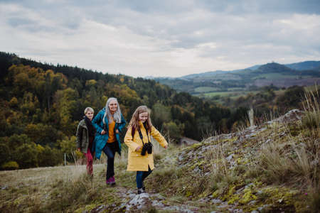 Small girl with mother and grandmother hiking outoors in nature.の写真素材