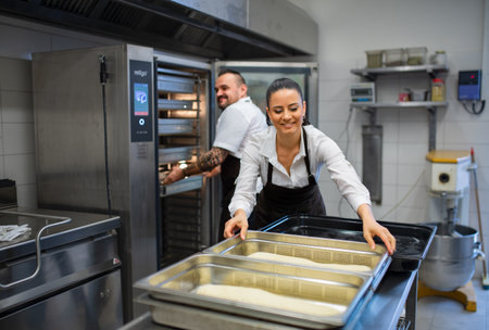 Chef and cook working on their dishes indoors in restaurant kitchen.