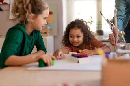 Happy little girls preparing for art class indoors at schoolの写真素材