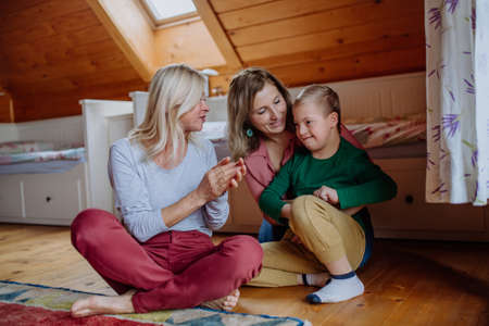 Boy with Down syndrome with his mother and grandmother at home.