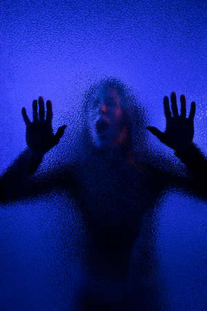 Shadow of woman screaming behind the glass, domestic violence concept.