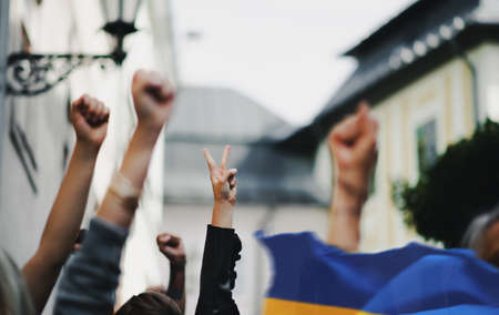 Arms and fists raised in the air, protest against Russian military invasion in Ukraine