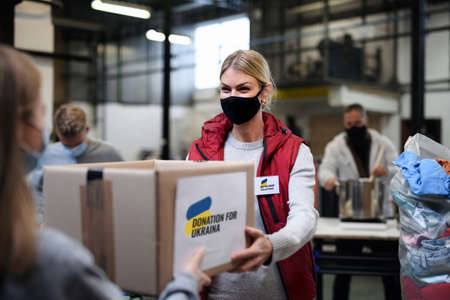 Volunteers collecting donations for the needs of Ukrainian migrants, humanitarian aid concept.の写真素材