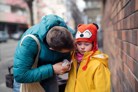 Father with his little daughter with Down syndrome on walk in town in winter.の写真素材