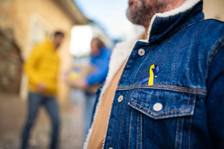 Protestors with Ukrainian blue and yellow ribbons protesting against war in Ukraine in street