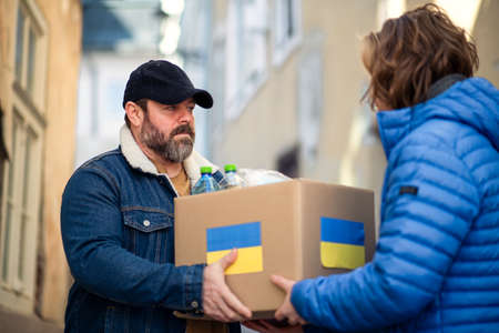 Volunteers collecting boxes with Humanitarian aid for Ukrainian immigrants in street.の写真素材