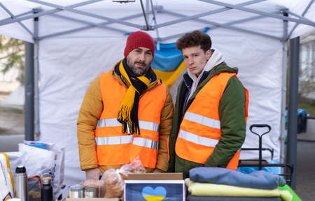 Team of volunteers distributing food, drinks and other donations to refugees on the Ukrainian...