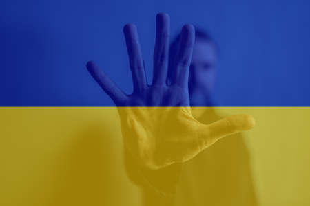 Double exposure of depressed mature man, alone in darkness, stop the war concept and Ukrainian flag.の写真素材