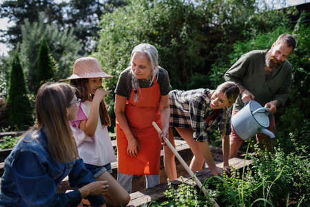 Happy farmers family working with garden tools outdoors at community farm.の写真素材