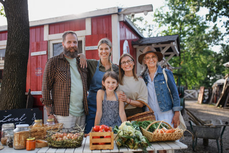 Family of farmers selling homegrown products at community farmers market, looking at camera.の写真素材