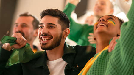 Brazilian young football fans celebrating their teams victory at stadium.の写真素材