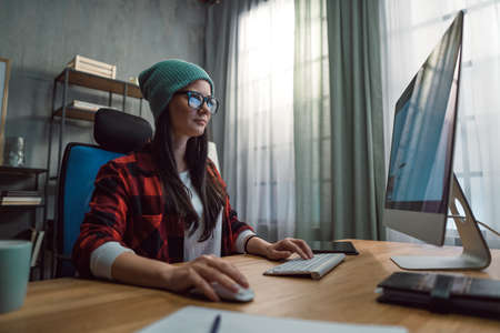 Happy female video editor works indoors in creative office studioの写真素材