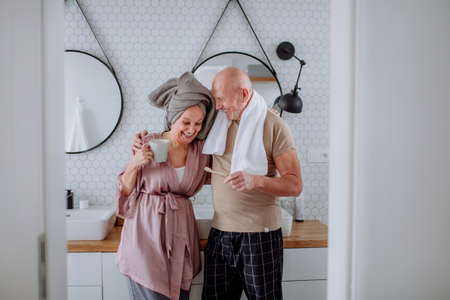 Senior couple in love in bathroom, brushing teeth and talking, morning routine concept.の写真素材