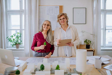 Mature women architects working together in office, looking at camera.の写真素材
