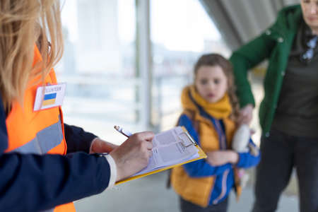 Volunteer registring Ukrainian refugees at train station.