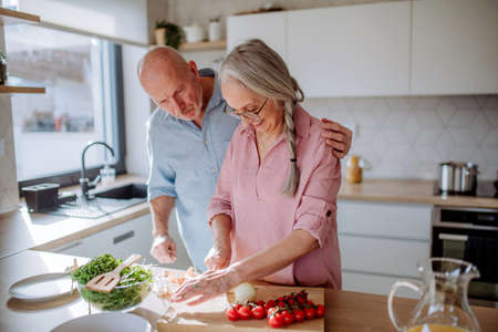 Happy senior couple cooking together at home.の写真素材