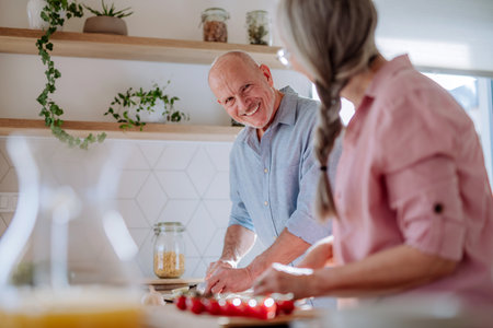 Happy senior couple cooking together at home.の写真素材