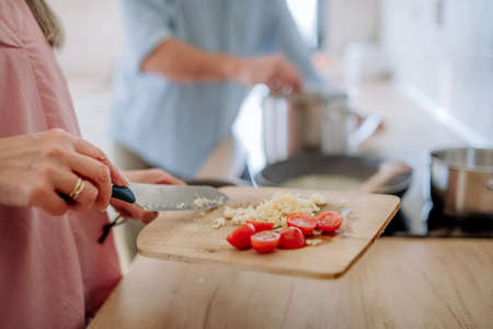 Happy senior couple cooking together at home, close-up.の写真素材