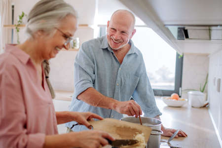 Happy senior couple cooking together at home.の写真素材