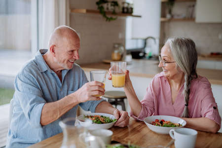Happy senior couple eating dinner together at home.の写真素材