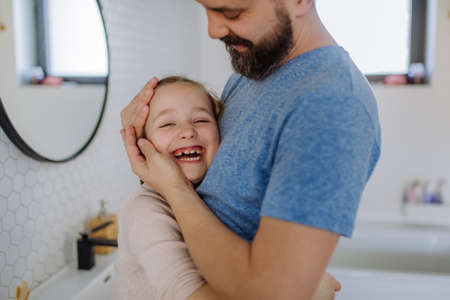 Happy father hugging his little daughter in bathroom.の写真素材