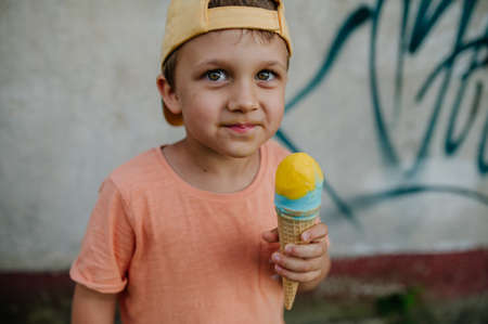 Little cute boy with ice cream outdoors in summer