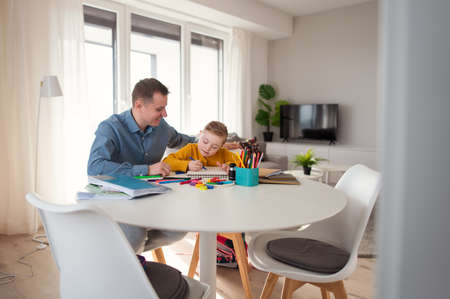 Father with his little daughter with Down syndrome learning at home.