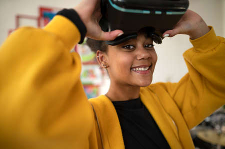 Happy student wearing virtual reality goggles at school in computer science classの写真素材