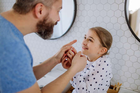 Father having fun with his little daughter in bathroom.の写真素材