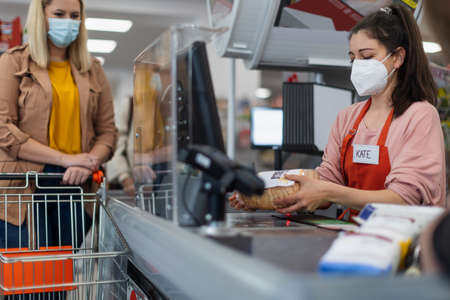A checkout counter cashier scans bread in supermarket.の写真素材