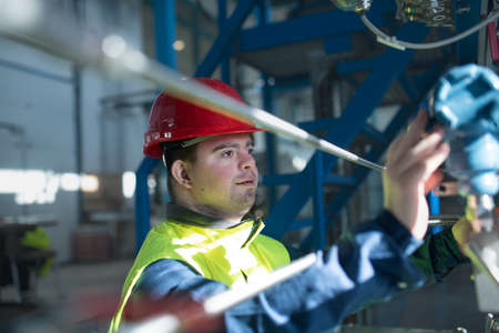 Young man with Down syndrome working in industrial factory, social integration concept.