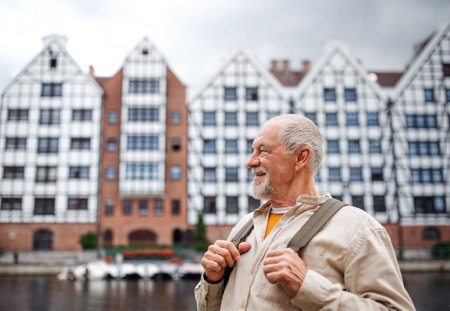 Senior man tourist outdoors sightseeing in historic town.の写真素材
