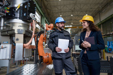 Female engineering manager and mechanic worker doing routine check up in industrial factory