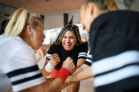 Group of young and old women in gym stacking hands together, sport team players.の写真素材