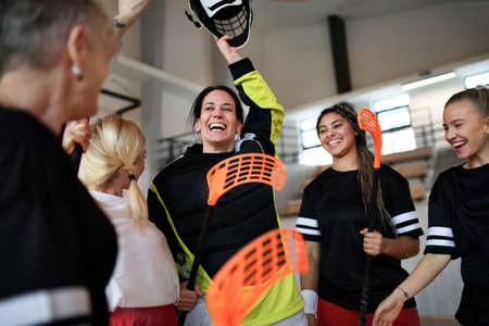 Group of young and old cheerful women, floorball team players, in gym cebrating victory.の写真素材
