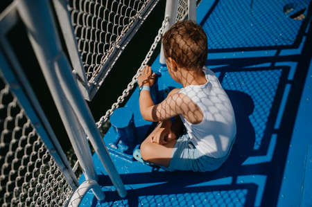 Little curious boy looking at water from motor boat.の写真素材