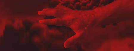 Male hands affected by blistering rash because of monkeypox infection on red background, wide bannerの写真素材