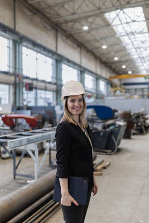Portrait of female chief engineer in modern industrial factory holding tablet.の写真素材