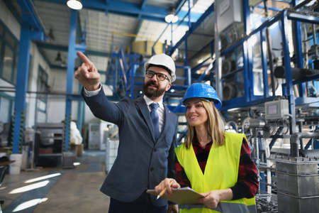 Engineering manager and mechanic worker doing routine check up in industrial factory