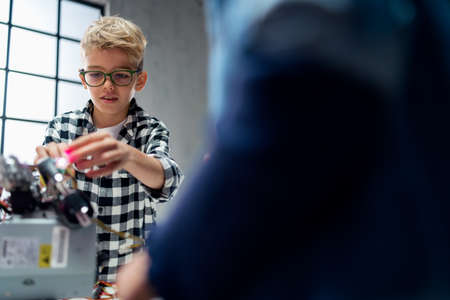 Pupil at school working with electronics component at robotics classroom.