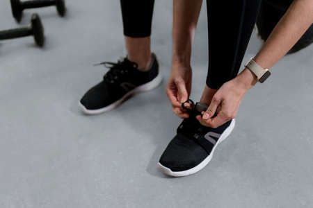 Close-up of woman Hands Tying Shoelaces On Fashion Sneakersの写真素材