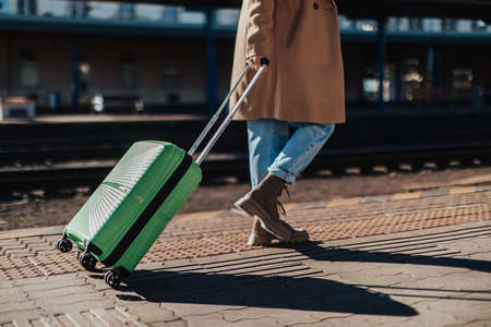 Woman traveler tourist waiting with luggage at train station, cut out.の写真素材