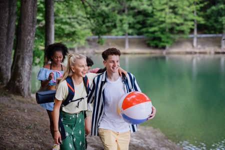 Group of young friends on camping trip near lake in summer.の写真素材