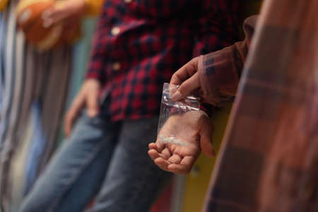 Unrecognizable high school students dealing drugs in shool corridor.の写真素材